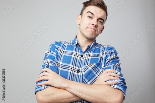 Self Confident guy dressed in a plaid shirt is on a white background in the studio photo