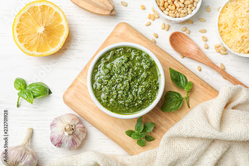 Flat lay composition with homemade basil pesto sauce and ingredients on table