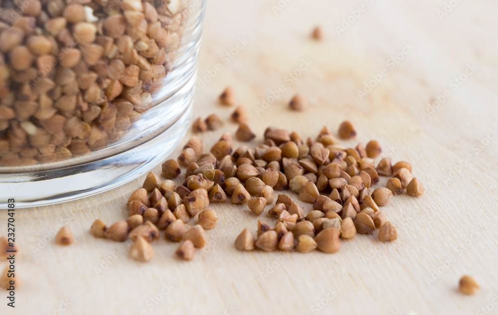 Buckwheat groats in a glass on a wooden table Buckwheat groats in a glass on a wooden table