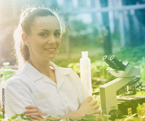 Woman agronomist with crossed arms in greenhose photo