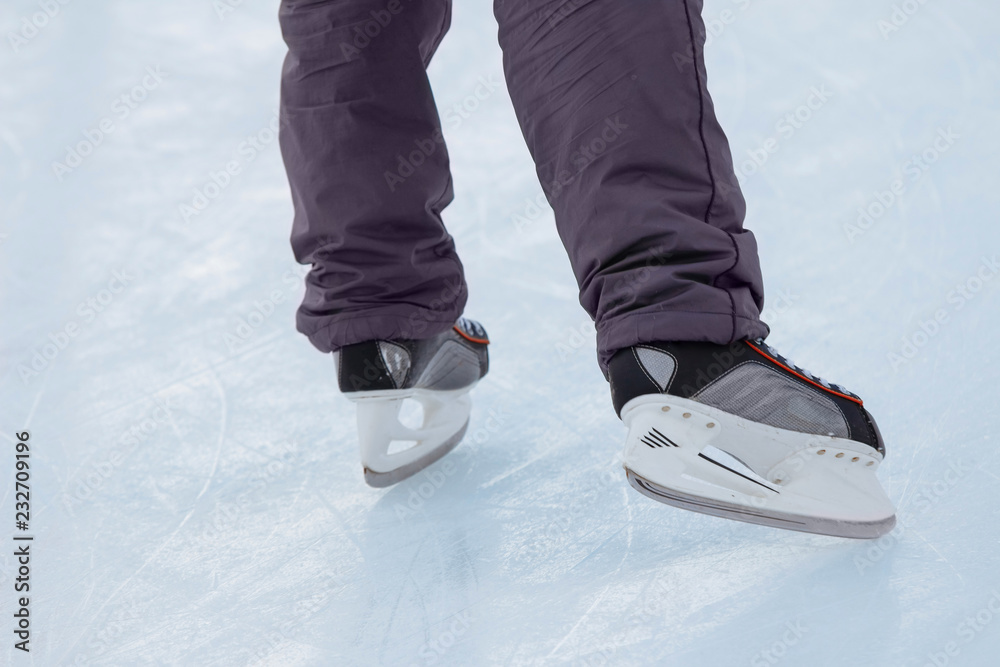 Close-up of ice skater's male feet on ice rink during ice hockey Close-up of ice skater's male feet on ice rink during ice hockey