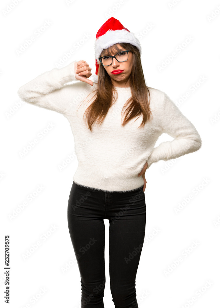 Girl with celebrating the christmas holidays showing thumb down sign with negative expression on isolated white background Girl with celebrating the christmas holidays showing thumb down sign with negative expression on isolated white background