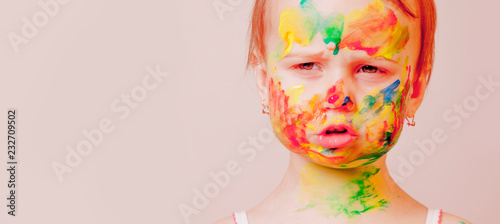 Fototapeta Naklejka Na Ścianę i Meble -  Hands and face of little cute child girl painted in colorful paints. Children's makeup. Humorous portrait.