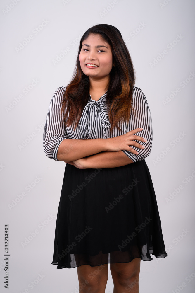 Studio shot of young happy fat Persian businesswoman smiling whi Studio shot of young happy fat Persian businesswoman smiling whi