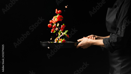 Fototapeta Naklejka Na Ścianę i Meble -  Chef preparing vegetables on a dark background on a grill pan