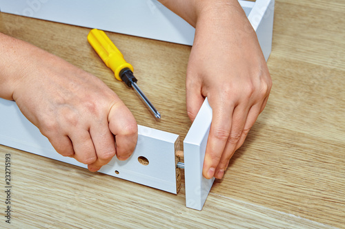 Furniture assembler joins together two parts of  furniture.