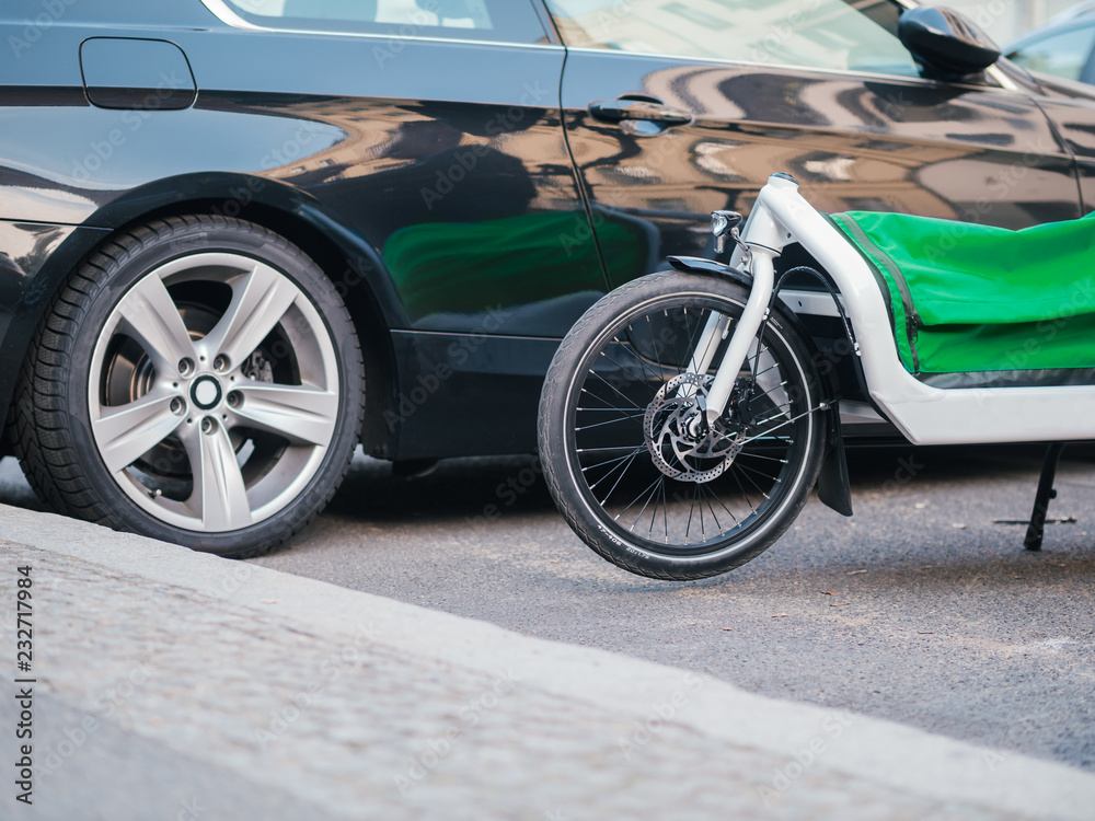 Mobilitätswende Transportfahrrad E-Bike neben Auto stehend