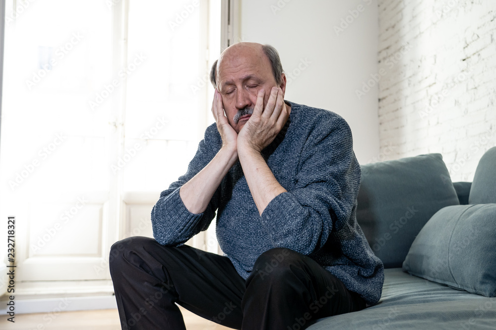Sad unhappy old senior man suffering from memory loss and alzheimer feeling depressed and lonely