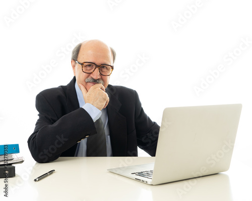 Pleased mature business man in his 60s working on laptop confident of success © SB Arts Media