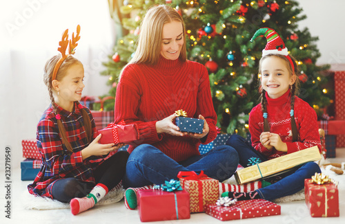 family   mother and children open presents on Christmas morning