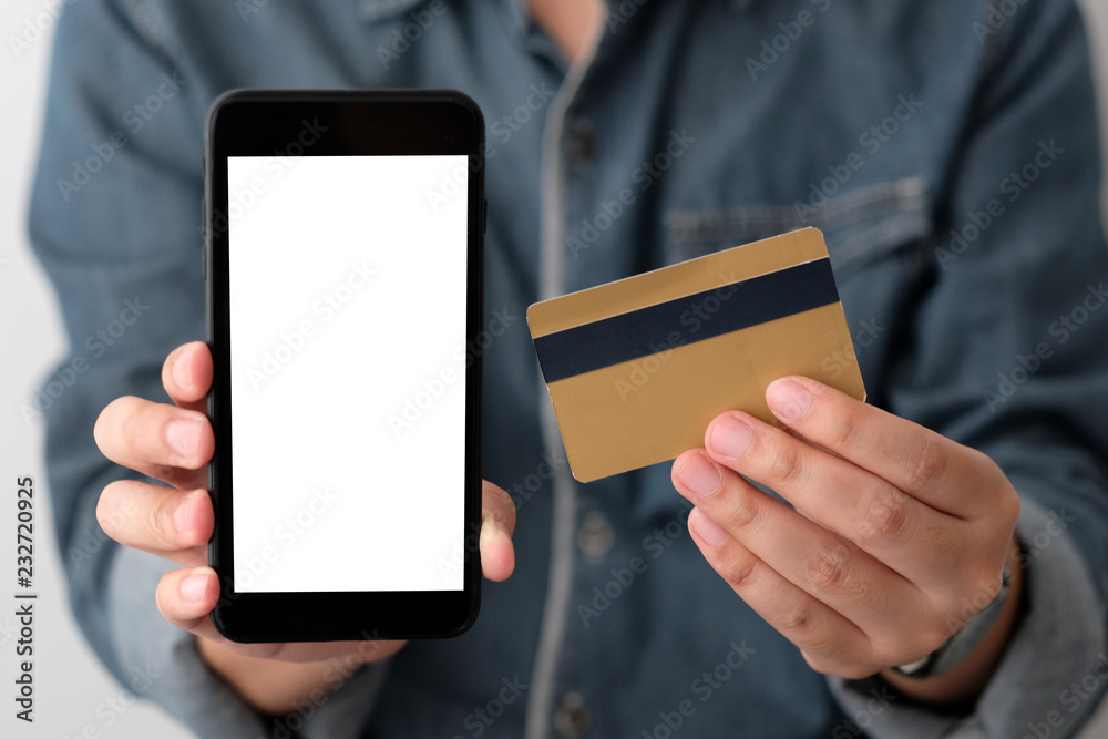 Hand holding credit card and smart phone with blank on screen for shopping online background, template, mock up, business and technology concept, online payment, digital money