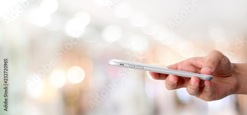 Hand using smart phone over blur bokeh light background  business and technology  internet of things concept