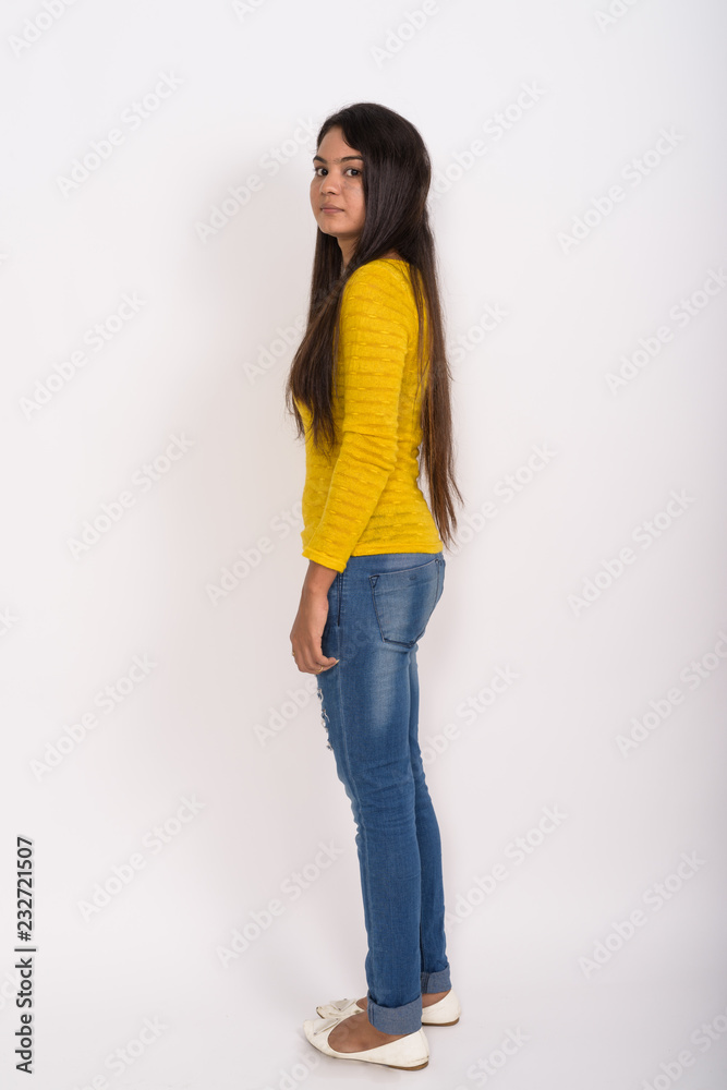 Full body shot of young Indian woman standing while looking at c Full body shot of young Indian woman standing while looking at c