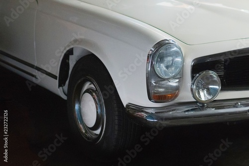 Weißer Oldtimer Sportwagen steht in einer großen Garage Tuch zum Abdecken hängt in die Windschutzscheibe © Petra