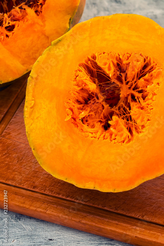 Part of the cut ripe pumpkin, orange pulp and fiber in the core.
