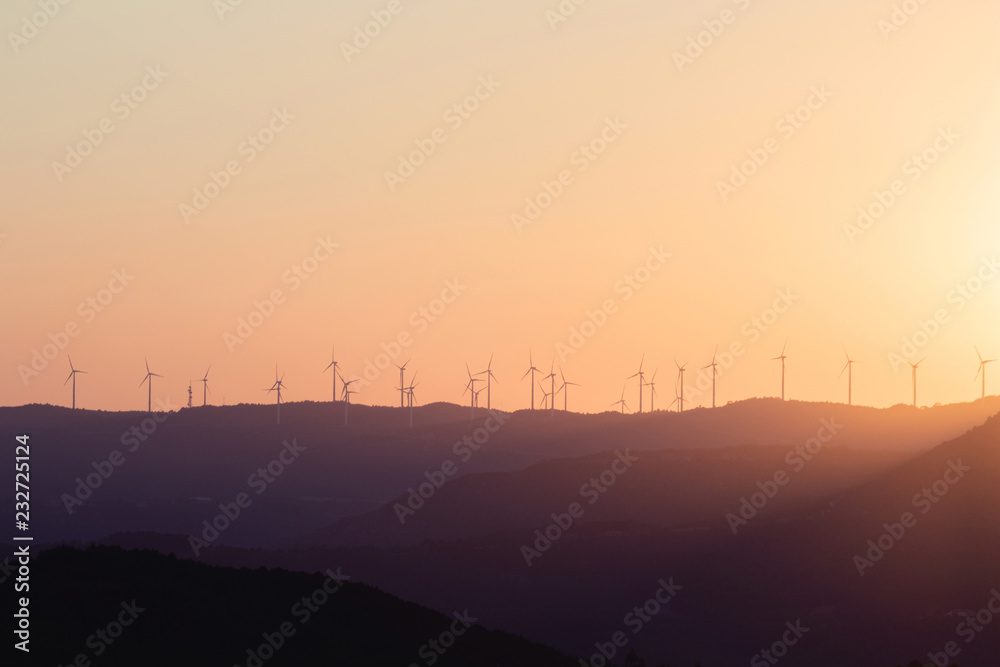 Late bright sunset with windmills on the horizon