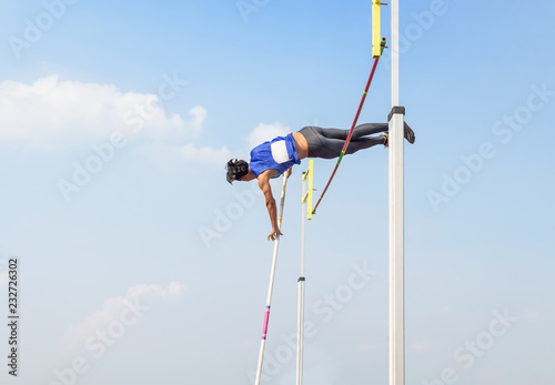 athlete pole vault pole jumping competition over bar in to the sky at stadium