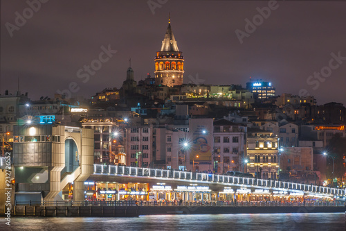 Galata Tower and Galata Bridge with lots of fish restaurant at night scene on Golden Horn Eminonu which is famous tourist area Istanbul, Turkey