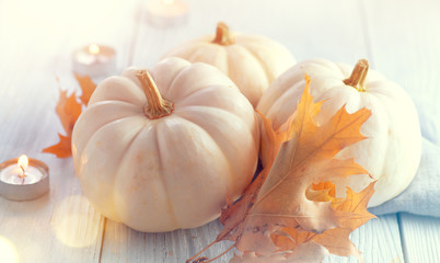 Thanksgiving background. Holiday scene. Wooden table, decorated with pumpkins, autumn leaves and candles