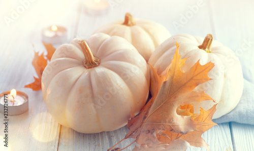 Thanksgiving background. Holiday scene. Wooden table, decorated with pumpkins, autumn leaves and candles