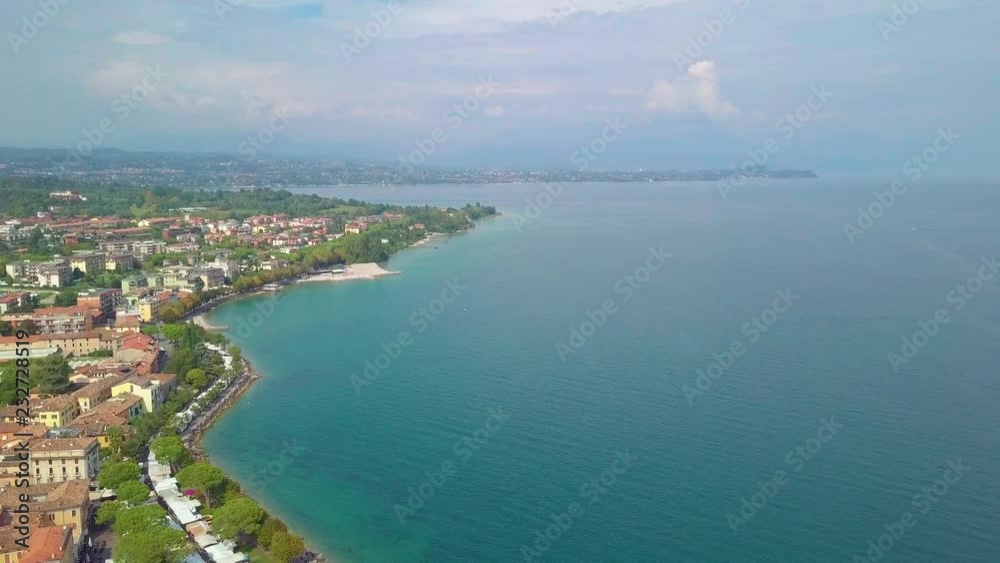 Aerial view of boats and coast of Lake Garda, Italy. Flying over boats and shoreline of Lago di Garda on summer holiday. Aerial view of boats and coast of Lake Garda, Italy. Flying over boats and shoreline of Lago di Garda on summer holiday.
