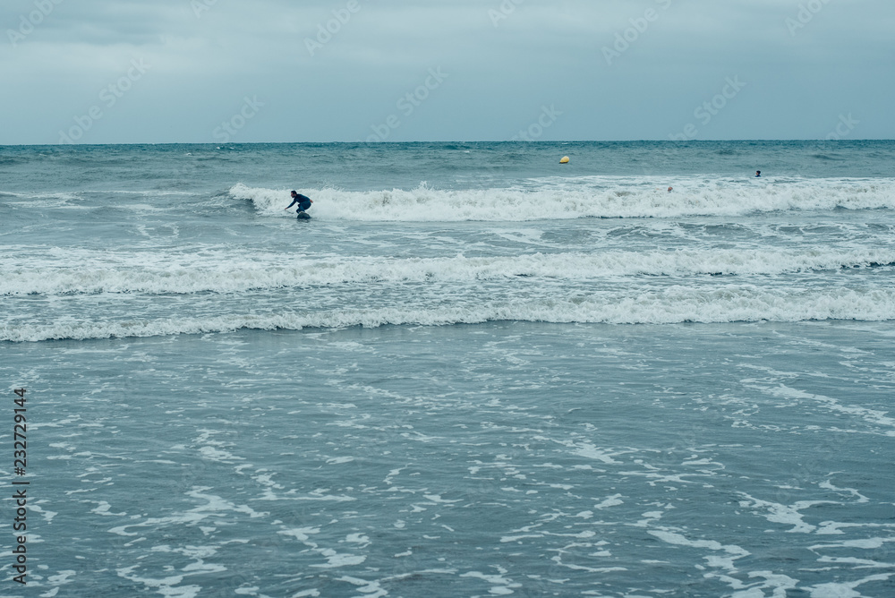 Valencia, Spain - September 30, 2018: Windsurfers trying to ride small waves during a storm. Valencia, Spain - September 30, 2018: Windsurfers trying to ride small waves during a storm.