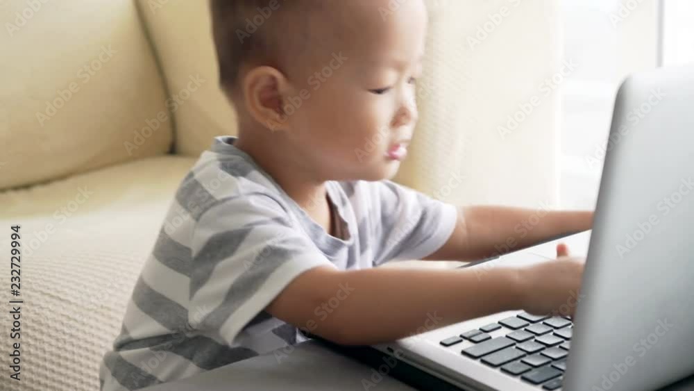 Child playing with laptop computer Child playing with laptop computer