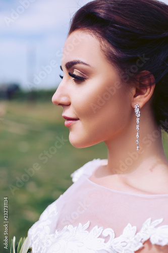 Beautiful young bride on nature in a wedding dress