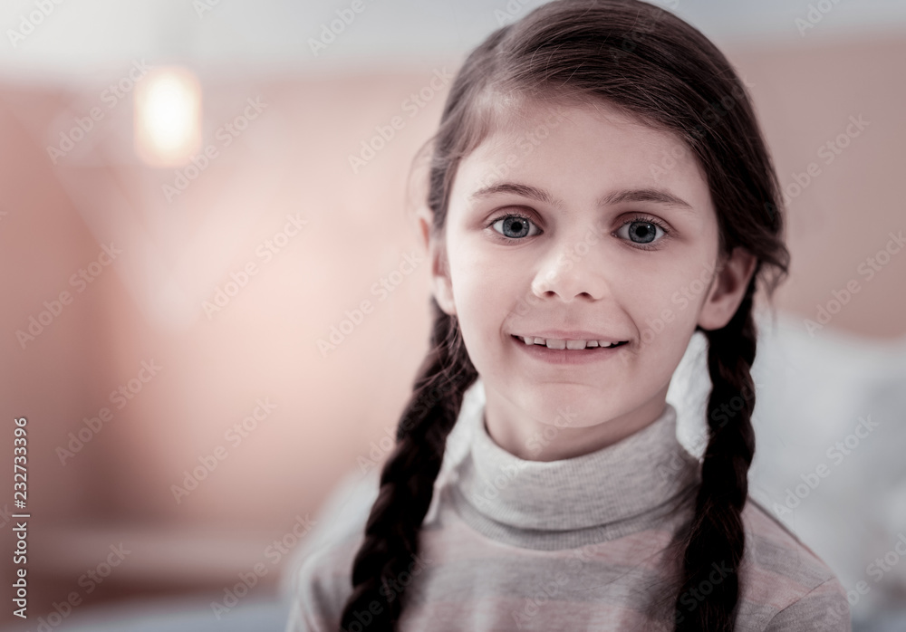 Cute girl. Portrait of adorable little child standing in front of you while smiling and having delighted mood