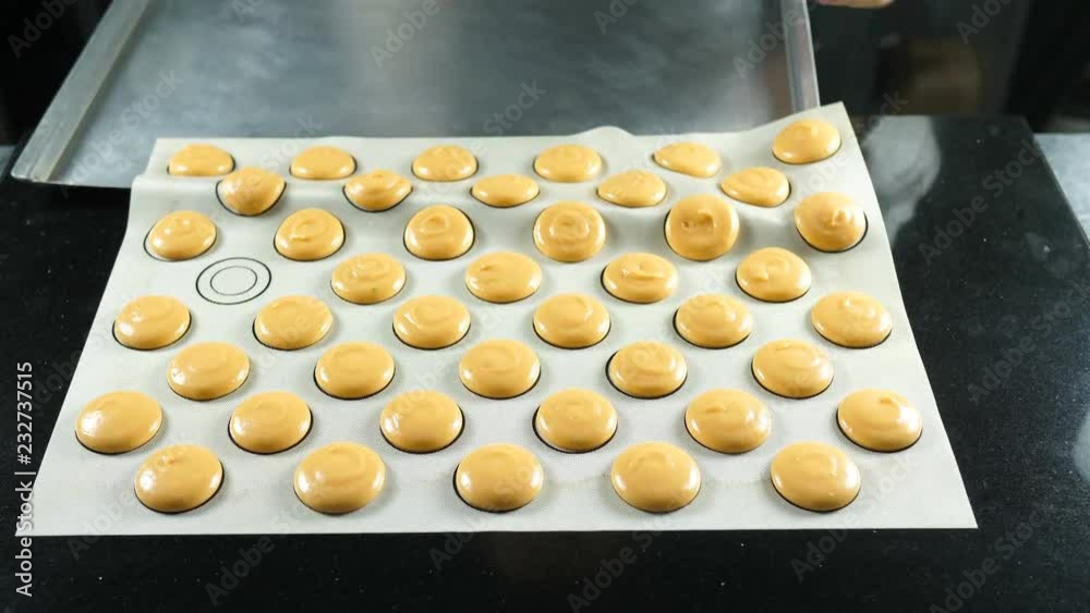 Macaroons on parchment, preparing for baking pasta. Hands prepare macaroons on the stencil. Macaroon cooking process Macaroons on parchment, preparing for baking pasta. Hands prepare macaroons on the stencil. Macaroon cooking process