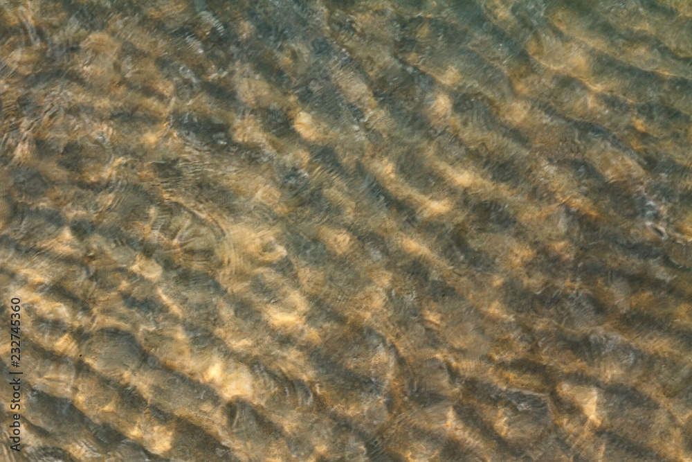Abstract image of top view of clear blue sea water over sand beach Abstract image of top view of clear blue sea water over sand beach
