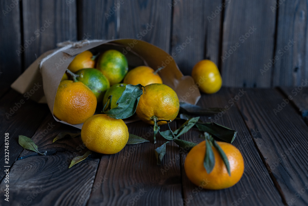 tangerines in paper packaging lie on a wooden table