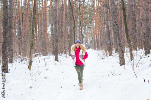 Nature and people concept - Portrait of running young blond woman in the winter park