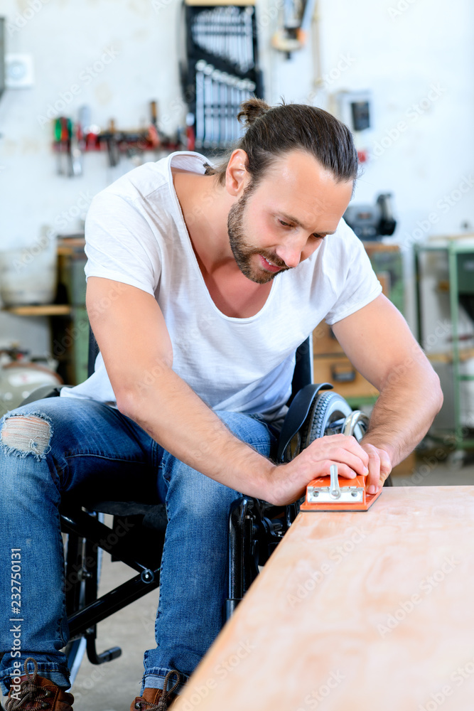 worker in wheelchairworkong in a carpenter's workshop