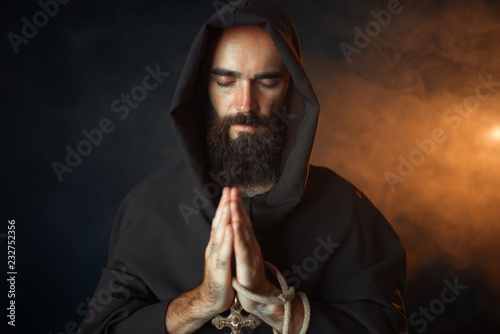 Medieval monk praying with closed eyes photo