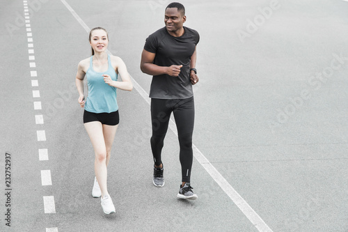 happy young couple afro-american man and european woman running together. A loving couple is run, engaged in sports, family values