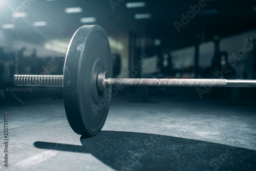Barbell on the floor in gym closeup view, nobody