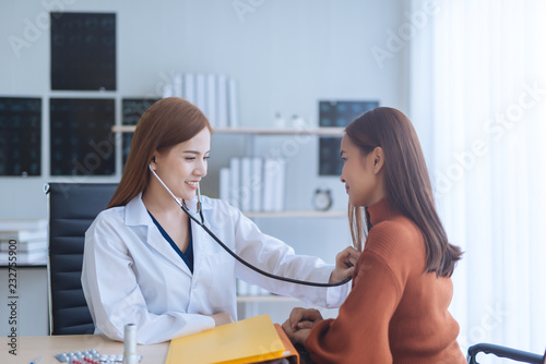 Asian woman doctor examining woman in a hospital