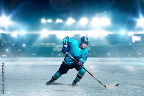 One hockey player skating with stick on ice arena