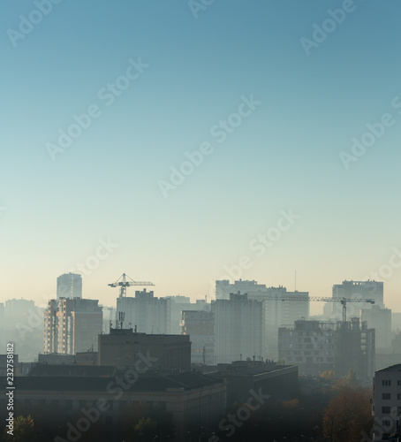 Cityscape at sunrise, building rooftops, bird view