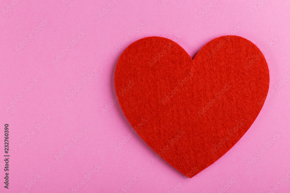 Red felt heart on bright pink background. St. Valentine's day