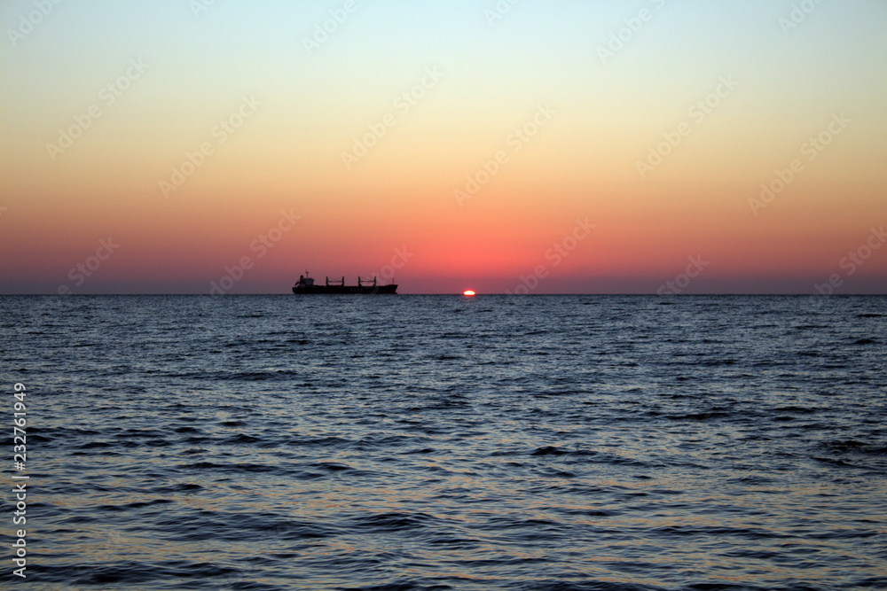 Cargo ship at sunset in the Black sea Cargo ship at sunset in the Black sea
