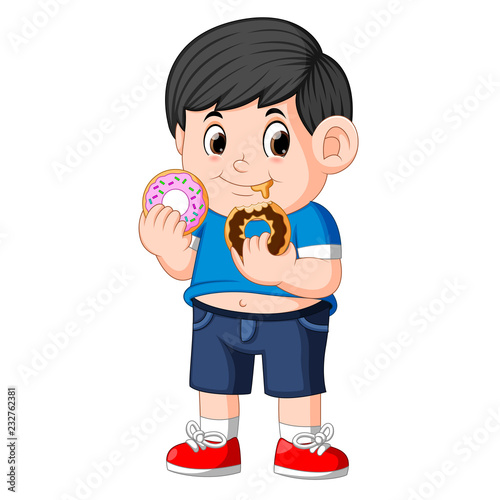 Little happy cute boy is eating two donut