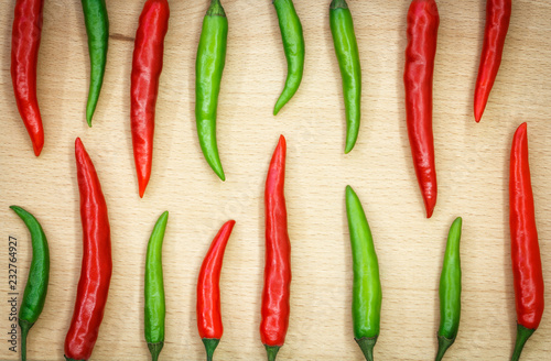 red and green hot chili pepper on a wooden surface