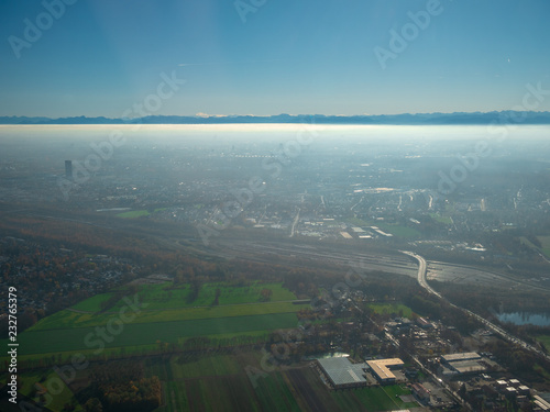 Helicopter view to Munich Region with autumn fog and long view to alps 