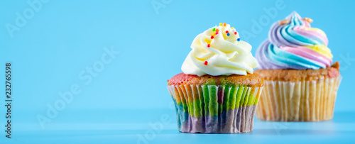 Colorful and enteresting cupcake isolated on blue background studio close up shot