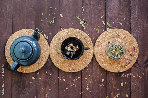 a small blue teapot, a mug of tea and dry herbal tea on a wooden background. Herbal medicine. tea from flowers.