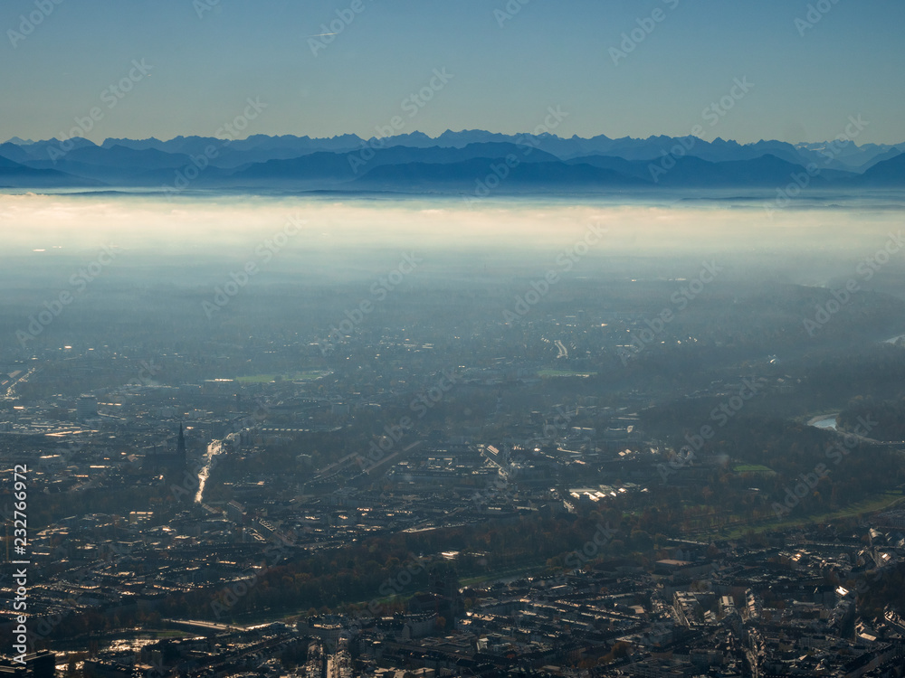 Helicopter view to Munich Region with autumn fog and long view to alps 