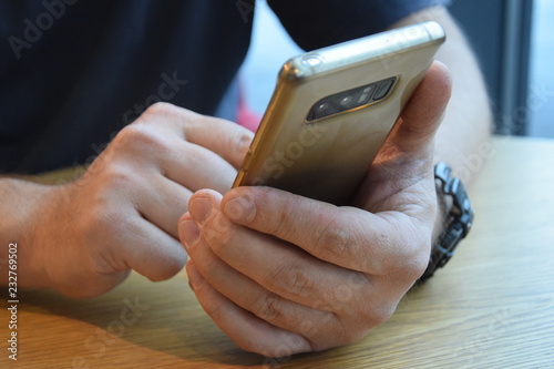 Hände eines Mannes mit Handy