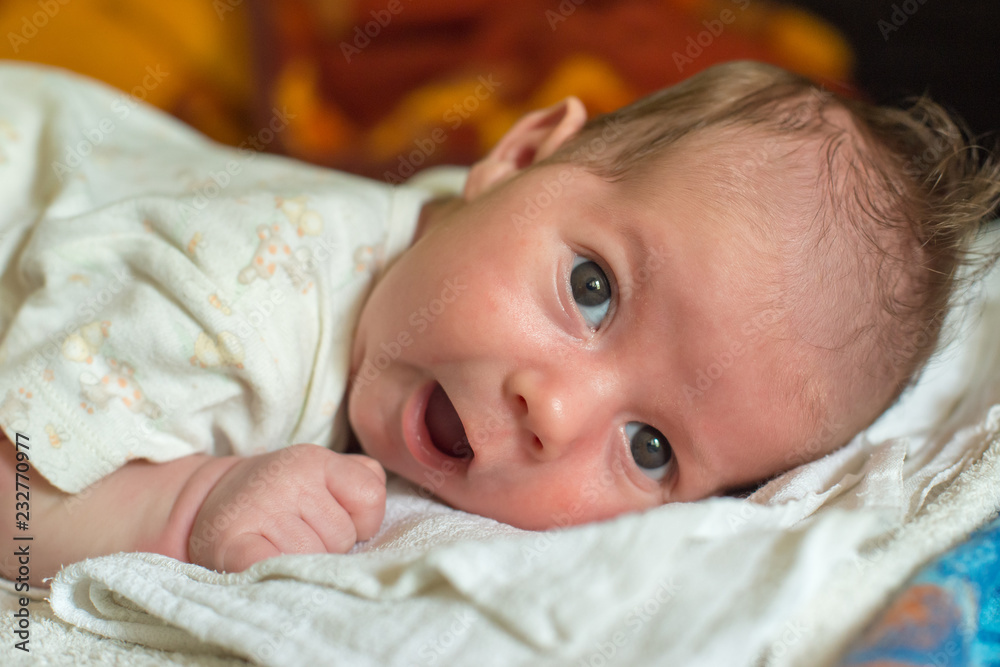 The newborn (one month old baby) lying on the bed The newborn (one month old baby) lying on the bed